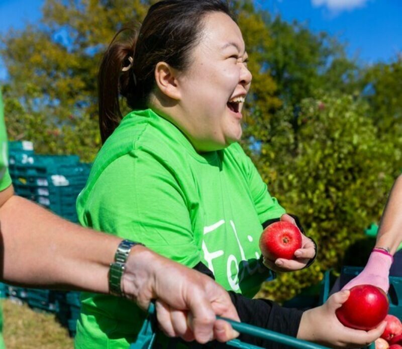 Woman laughing holding apples